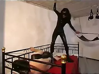 Hot dominatrix whipping her slave